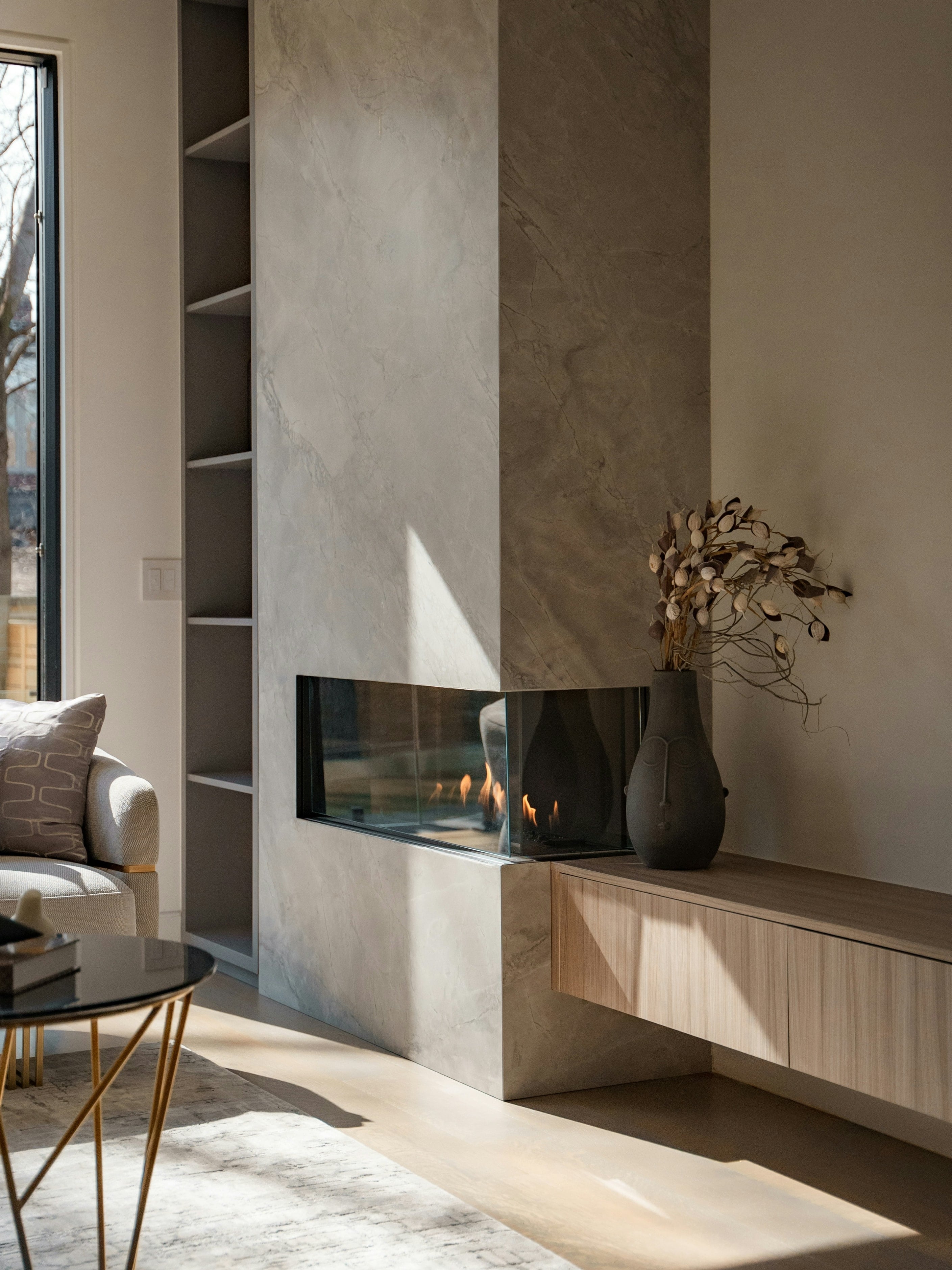 A living room with a stone fireplace in afternoon light