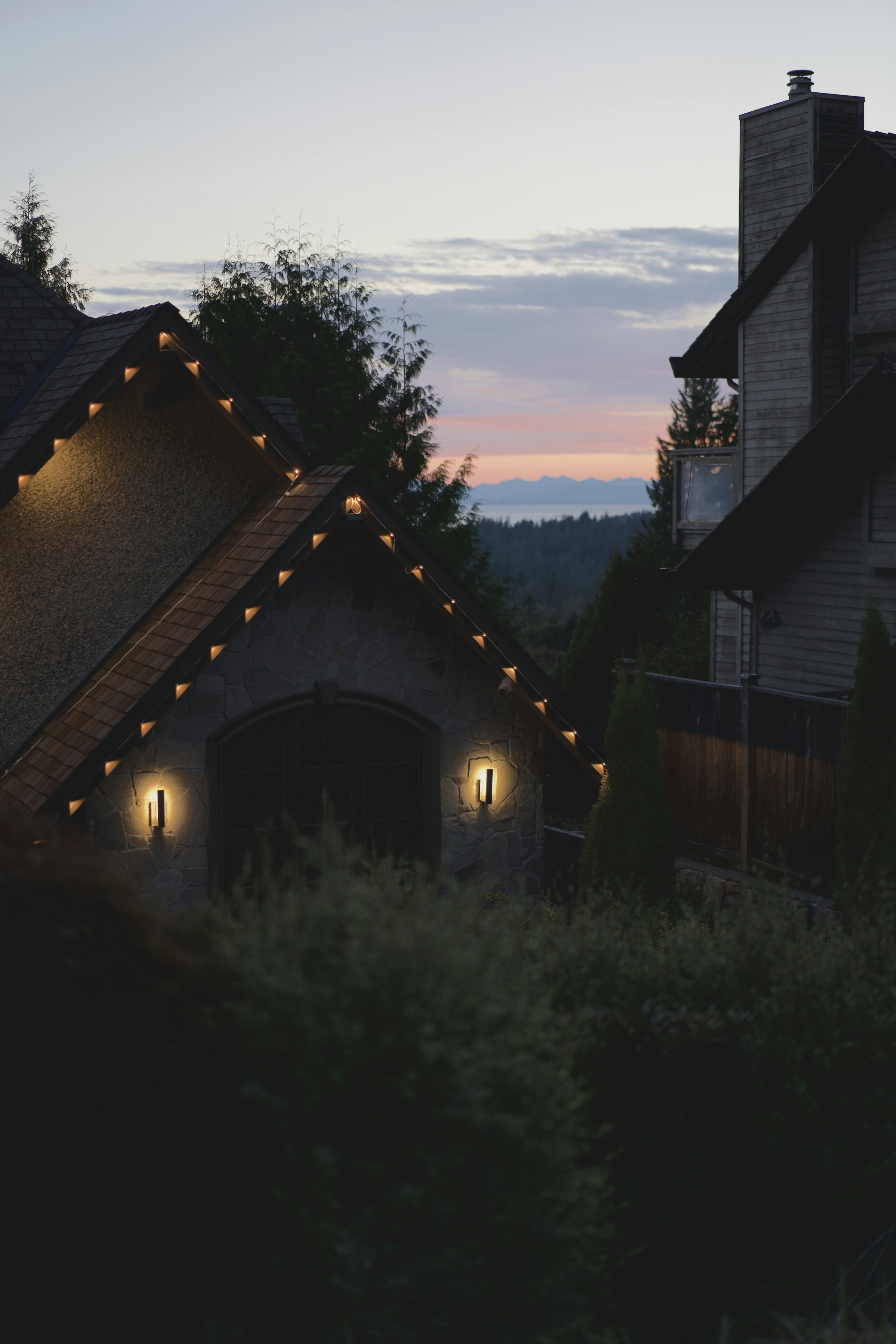 A stone house with its lights on at dusk