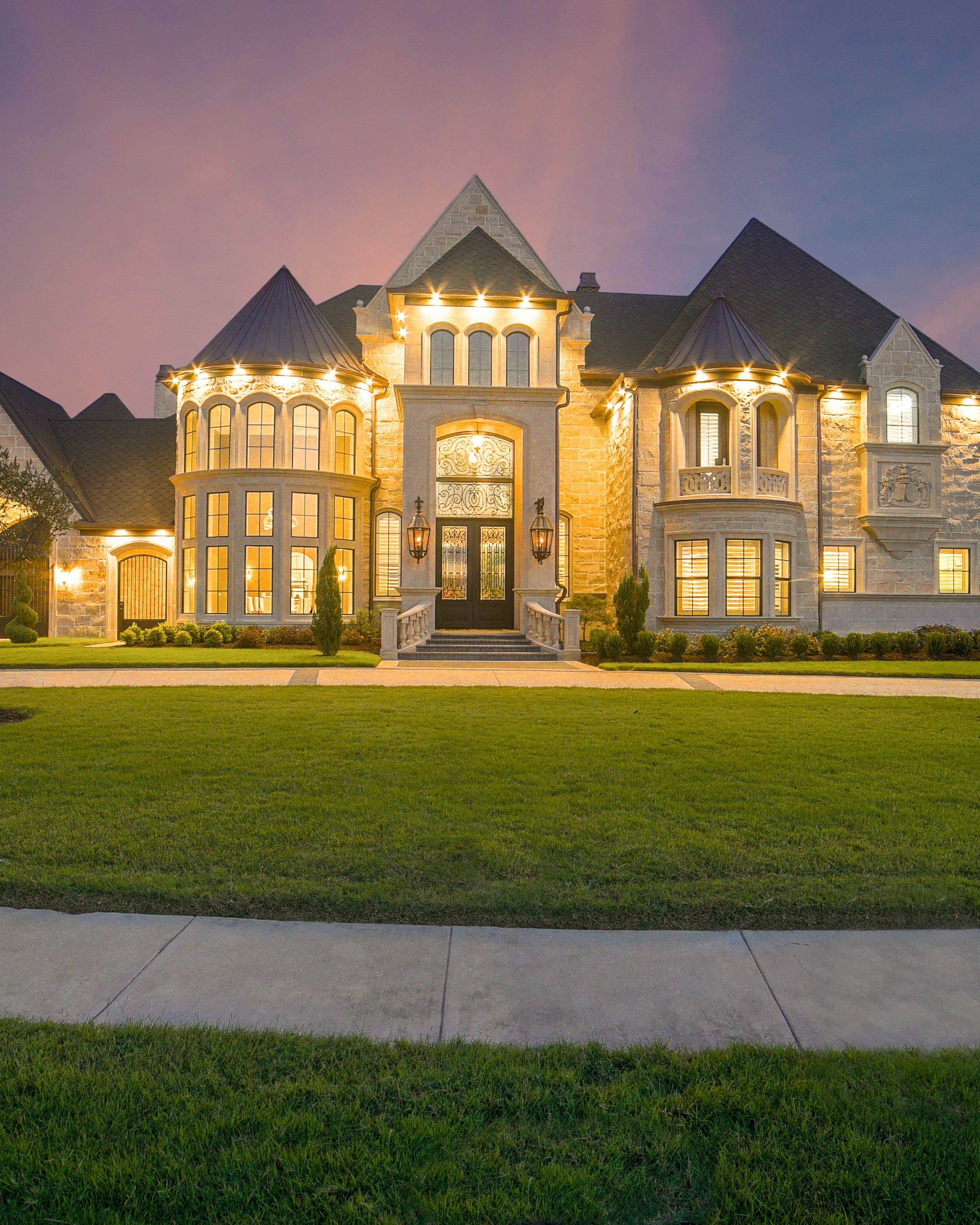 A large house at dusk with its windows lit